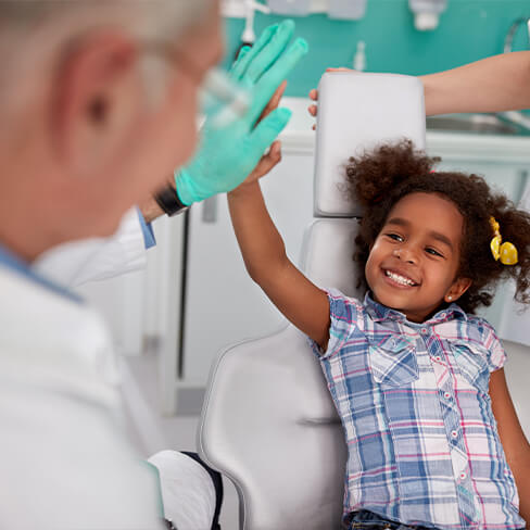 Dentist giving smiling child a high five