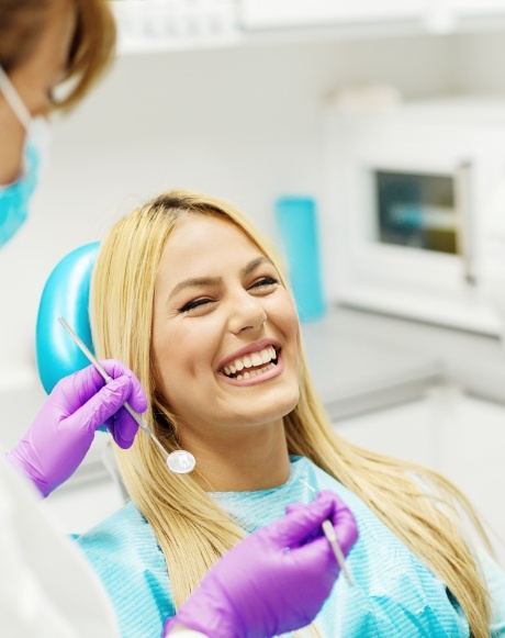 Woman in dental office laughing with dentist