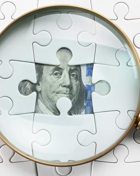Magnifying glass inspecting a bill hidden behind a puzzle