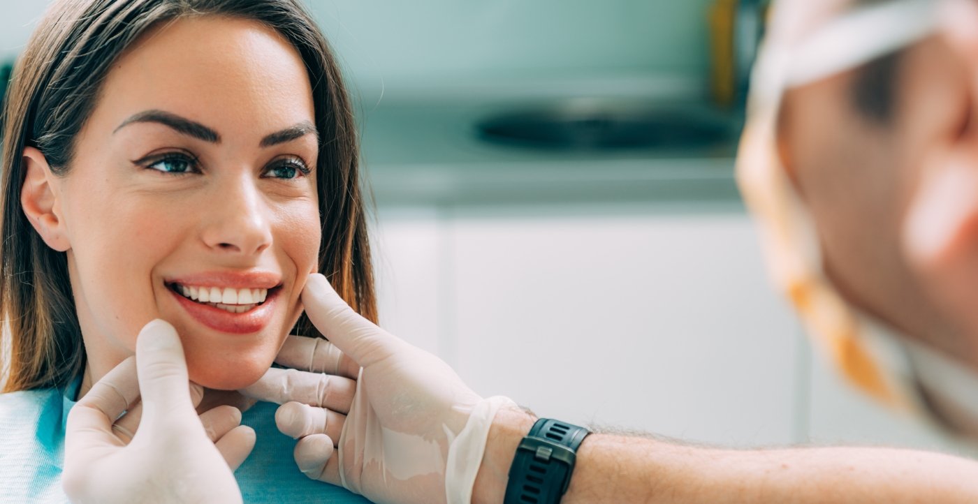 Dentist examining woman's flawless smile after cosmetic dentistry