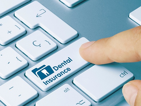 Finger pressing key that says Dental Insurance