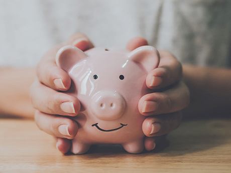 Close-up of piggy bank held between two hands