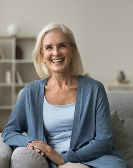Senior woman leaning on couch and smiling