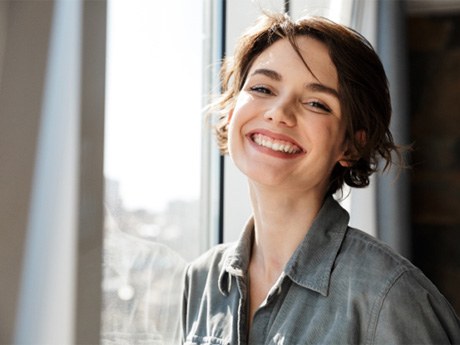 young woman smiling after prevent dental emergencies in Huntsville