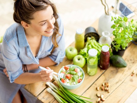 young woman eating healthy food to prevent dental emergencies in Huntsville