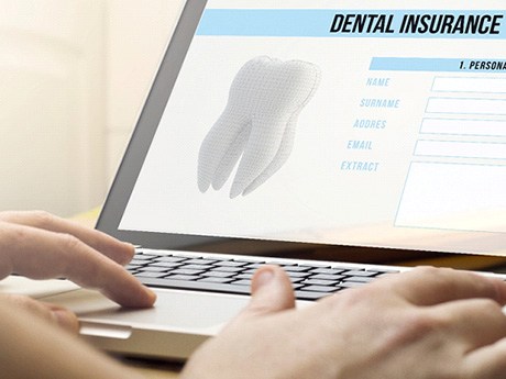 Filling out a dental insurance form on a laptop