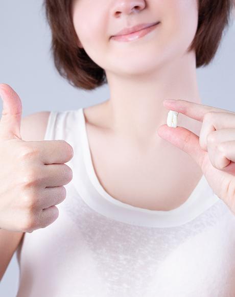 Woman holding tooth after tooth extraction in Huntsville, OH