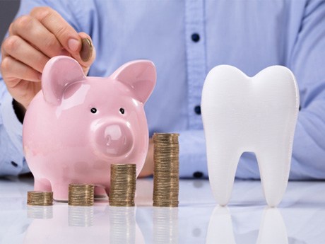 tooth and piggy bank for cost of dental implants in Huntsville         