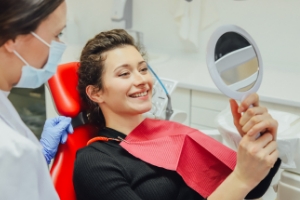 Woman looking at smile during dental office visit
