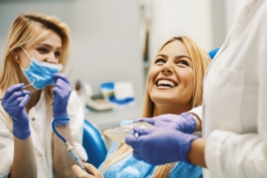 Dental patient laughing with dentist and dental team member