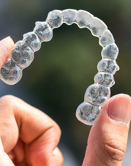 Someone holding an Invisalign tray