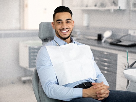 Man with straight teeth smiling while sitting in treatment chair