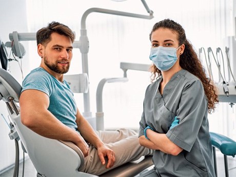 a patient and dentist looking at the camera  