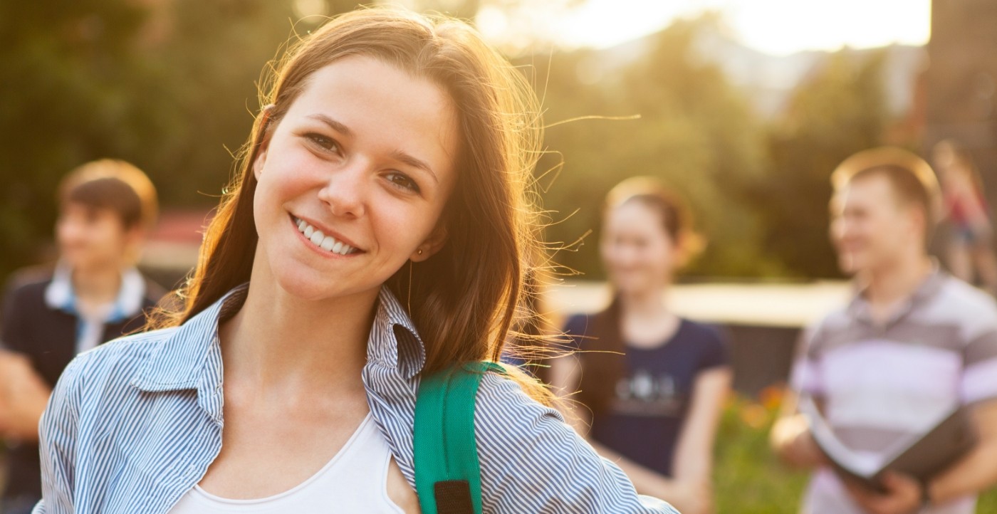 Young woman with straight smile after orthodontics treatment