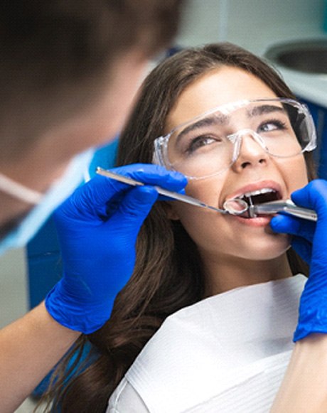 A dentist performing a root canal on a young woman