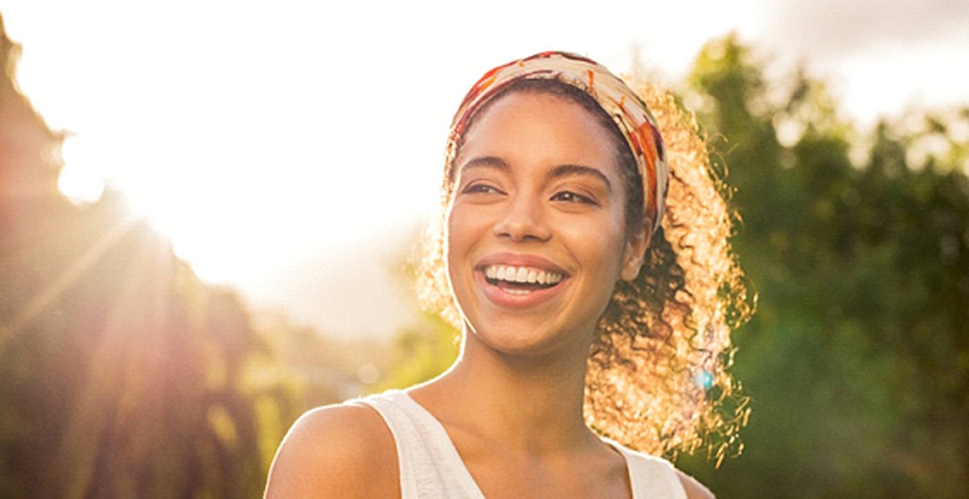 A woman smiling at sunset while outdoors