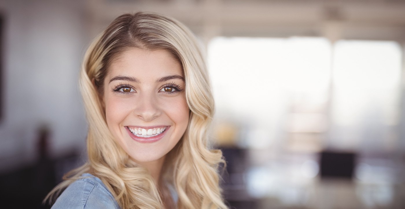 Young woman smiling after teeth whitening in Huntsville