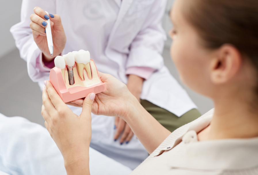 Dentist showing patient model dental implant